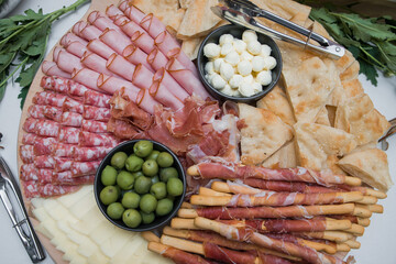 Mixed sliced meat and cheese platter party catering mediterranian snack food