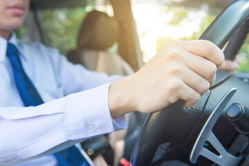 Driving a car, hands on steering wheel