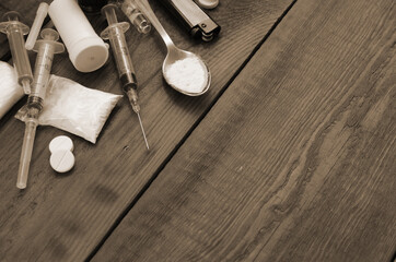 A lot of narcotic substances and devices for the preparation of drugs lie on an old wooden table