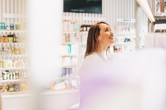 Adult Pretty Smiling Woman With Dark Hair In The Cosmetics And Perfume Store, Holiday Shopping