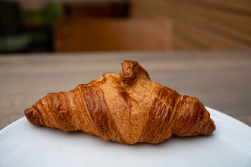 close up croissant on white plate