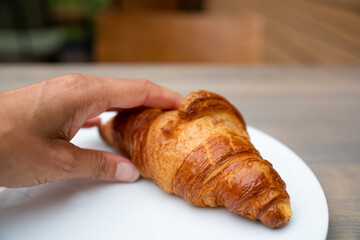 hand grabs a croissant