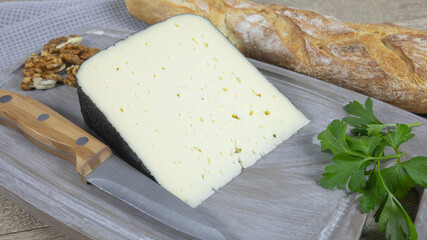 tranche de fromage tomme noire des Pyrenees sur une planche à découper