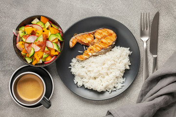 Fish salmon grill with rice and vegetables on a plate on the table. Top View