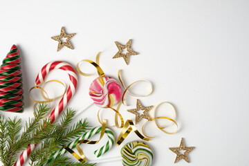 Flat lay. New year and christmas theme. Christmas tree branches, toys and candies. White background.