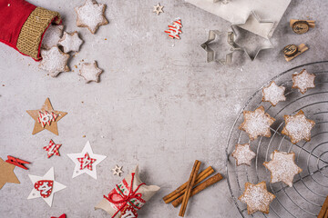 Zimtsterne Gebäck auf einem Küchentisch verteilt, mit Zimtstangen, Ausstechform und Deko, draufsicht