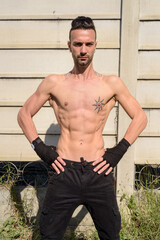Obraz premium Portrait of young handsome fighter man with lean muscular body outdoors