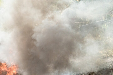 Soldier with machine guns in the smoke from the fire in uniform