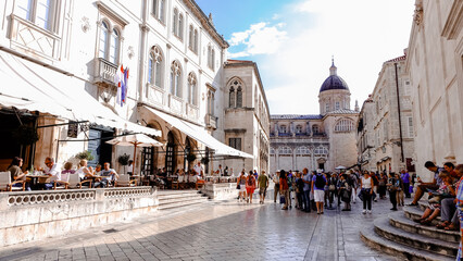 Lively scenery at Dubrovnik old town. People walking and seating in the cafe at Dubrovnik old city with the view of Dubrovnik Cathedral