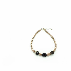 Women's bijouterie. Necklace made of pale pink and black and white beads. Metal clasp. Isolated on white background.