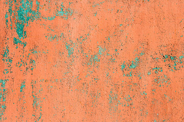 Old rusty metal wall with peeling and peeling red and burgundy paint
