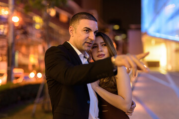 Portrait of couple traveling outdoors at night in the city at Bangkok Thailand