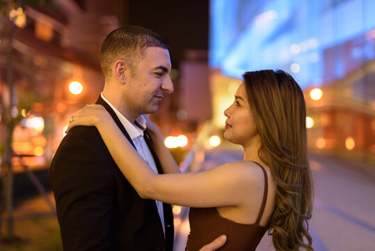 Portrait Of Couple Looking Each Other Outdoors At Night In The City At Bangkok Thailand