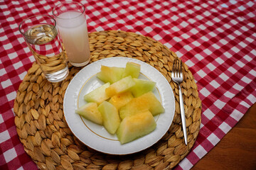 Turkish raki and melon on red white striped table cloth