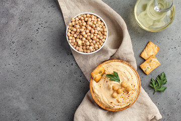 Flatlay hummus in a wooden plate, chickpeas, croutons. Dishes of chickpeas, a vegetarian dish. Copy space.