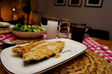 Turkish raki and roasted bonito fish with appetizers on the table