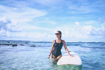 Extreme Water Sport. Surfing. Healthy Athletic Young Surfer Girl With Sexy Fit Body Holding Surf Board While Standing In Clear Water, Summer Vacation. Lifestyle. Leisure, Hobby, Wellness, Fitness.