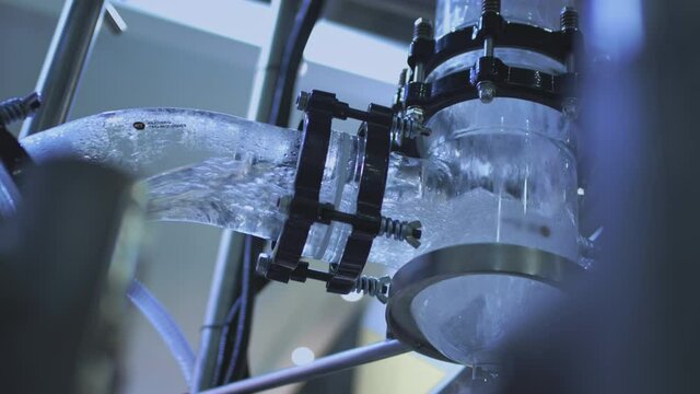 Water pump and pipes. Transparent pipe to show water flows inside the water supply system.