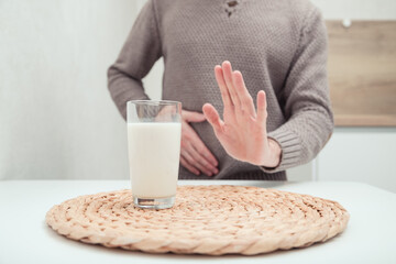 Man feels bad, lactose intolerance. Dairy intolerant person. Health care concept and milk