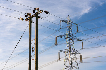 Examples of two overhead electricity pylons. Lattice steel pylon and a wooden pole pylon. Hertfordshire. UK