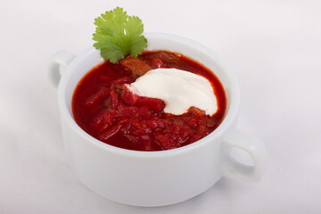 Ukrainian borscht with sour cream in a white plate