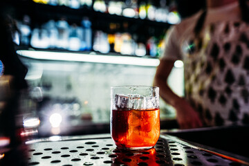 a glass of alcoholic cocktail on a table in a bar