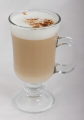 Cappuccino with cinnamon in a glass glass
