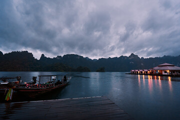 Naklejka na ściany i meble Traditional wooden boats on wharf in Cheow Lan Lake, Khao sok national park at night time, Thailand.