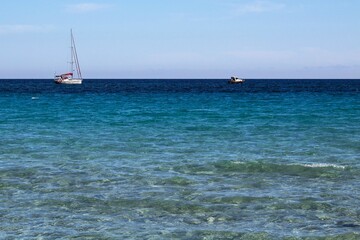 Obraz premium evocative image of the sea of many colors and boats in the background
