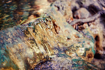 Closeup of stream water texture running on rock.