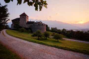 Fototapeta na wymiar Vaduz Castle, the official residence of the Prince of Liechtenstein, with Alps mountains in background on sunset.