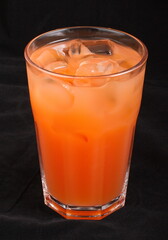 Grapefruit juice with ice cubes in a glass Cup