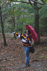 A woman with an umbrella in an autumn day in middle of the wood