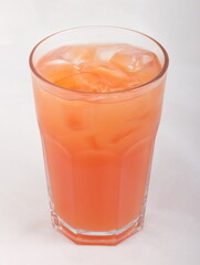 Grapefruit juice with ice cubes in a glass Cup