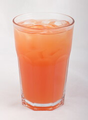 Grapefruit juice with ice cubes in a glass Cup
