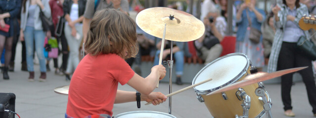 young white man busker drummer drumming in the street. concept. baner 