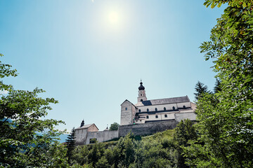 Beautiful summer landscape with ancient monastery in mountains. Benedictine Abbey of Monte Maria in the Venosta valley, South Tyrol, northern Italy, Europe.