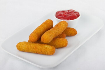 Mozzarella cheese sticks with ketchup on a white plate