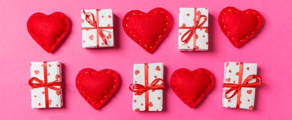 Composition of holiday white gift boxes and red textile hearts on colorful background. Valentine's day concept