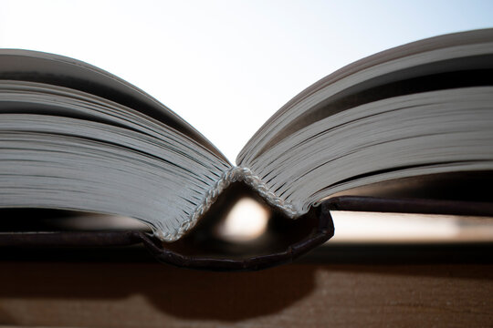 One open book on the windowsill. Light background.
