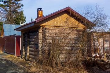 Log building of bathhouse in a village in spring day, Russia