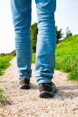 close up Hiker (jeans and shoes) on gravel path