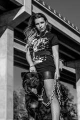Modelo posando para una sesión en el campo con cadenas y un perro