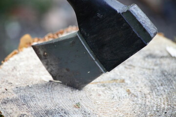Modern axe blade in a log close-up, woodman equipment tool