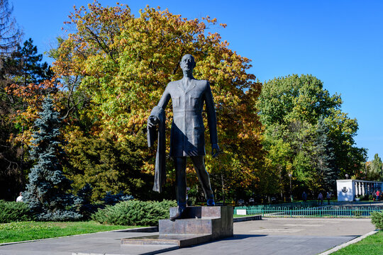 Charles de Gaulle statue and large green and yellow trees at the entry in Herastrau Park in Bucharest, Romania, in a sunny autumn day.