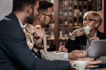 Business people holding a meeting at office cafeteria discussing about business plan.