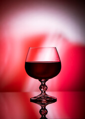 
Glass with red wine on gradient background