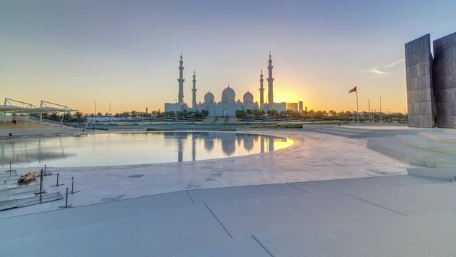 Sheikh Zayed Grand Mosque in Abu Dhabi at sunset timelapse, UAE. Evening view from Wahat Al Karama with reflections on water