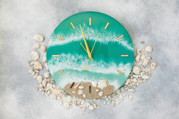 Wall clock made of resin art with sea waves and beach. Flat lay