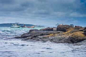 sea ​​with big rocks boats and a cloudy day
